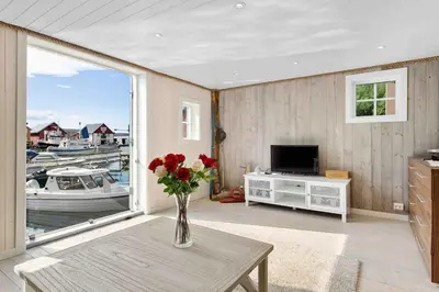 a living room with a vase of flowers on a table at Raffelbrygga in Bud