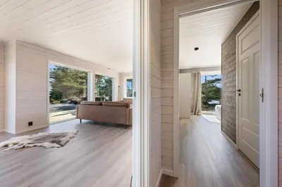 a pivot door in a house with a living room at Ny feriehytte i skjærgården in Austevoll