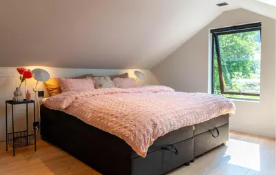a bedroom with a large bed with a large window at Luxurious Home In Ytre Arna With Wifi in Ytre Arna