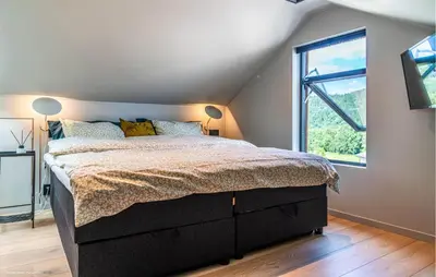 a bedroom with a large bed and a window at Luxurious Home In Ytre Arna With Wifi in Ytre Arna