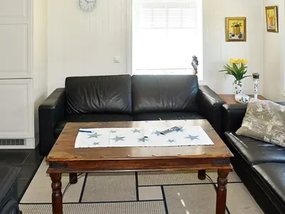 a living room with a black leather couch and a coffee table at 5 person holiday home in Oksvoll in Oksvoll