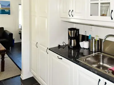 a kitchen with white cabinets and a sink at 5 person holiday home in Oksvoll in Oksvoll