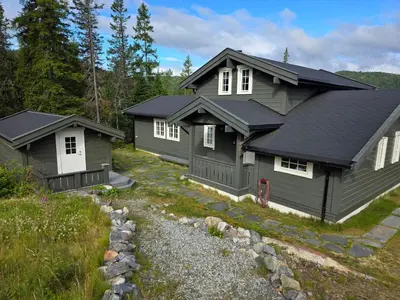 a home with a gray house and a yard at Mountain Cabin With Views Of Bonsenås in Tuddal