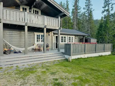 a large wooden house with a porch and a deck at Mountain Cabin With Views Of Bonsenås in Tuddal