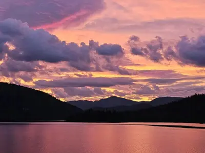 a sunset over a lake with mountains in the background at Mountain Cabin With Views Of Bonsenås in Tuddal
