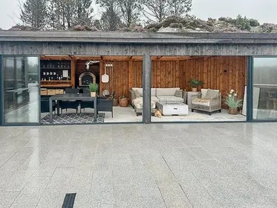 a house with a living room and a patio at Modern Cabin With Archipelago Views in Bremnes