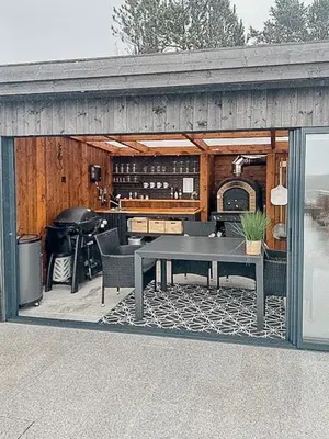 a screened in patio with a table and a grill at Modern Cabin With Archipelago Views in Bremnes