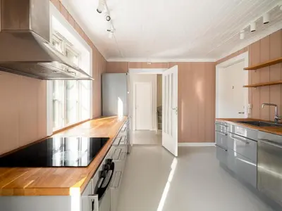 a kitchen with pink walls and a wooden counter top at Sentralt beliggende enebolig på Møllenberg in Trondheim
