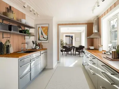 a kitchen with white cabinets and a dining room at Sentralt beliggende enebolig på Møllenberg in Trondheim