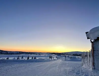 a snow covered field with a house in the foreground at Pellestova - Hafjell in Øyer