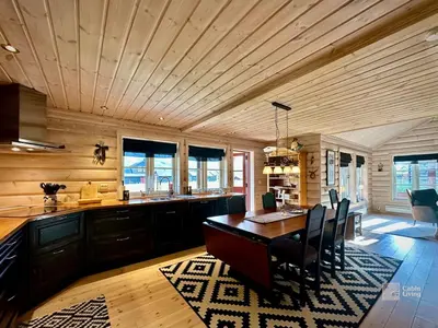 a kitchen with a wooden ceiling and a table and chairs at Indoor hot tub, views & nature, cosy family cabin at Filefjell in Tyinkrysset