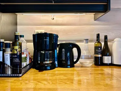 a coffee maker on a counter with bottles of wine at Indoor hot tub, views & nature, cosy family cabin at Filefjell in Tyinkrysset