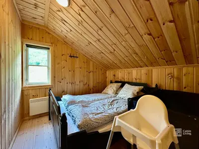 a bedroom with a bed in a wooden cabin at Indoor hot tub, views & nature, cosy family cabin at Filefjell in Tyinkrysset