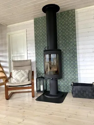 a fireplace in a living room with a couch and a chair at Great cabin in beautiful nature in Ørsta