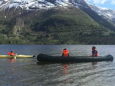 a group of three people in a canoe on a lake at Great cabin in beautiful nature in Ørsta