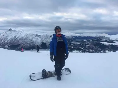 a person standing in the snow with a snowboard at Great cabin in beautiful nature in Ørsta