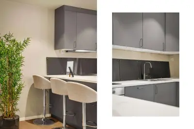 a kitchen with gray cabinets and a kitchen island with stools at 307SB10 - Three Bedroom Stay in Bergen
