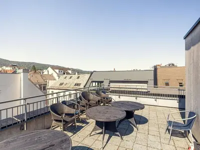 a patio with tables and chairs on a balcony at Modern apartment in the middle of Bergen city center in Bergen