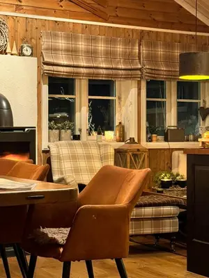 a living room with chairs and a table and windows at Log Cabin At The Foot Of Hallingskarvet in Hovet
