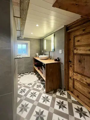a bathroom with a sink and a mirror and a counter at Restored Farmhouse By The Sea In Kvalheim in Raudeberg