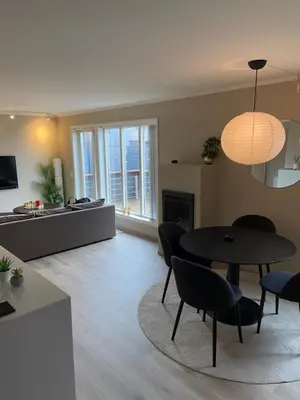 a living room with a table and chairs at Great and modern apartment at Grilstad Marina! in Trondheim