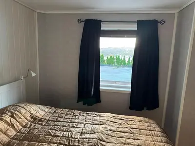 a bedroom with a window with a view of the water at Bergtun's Corner - Sotra Vest in Sekkingstad