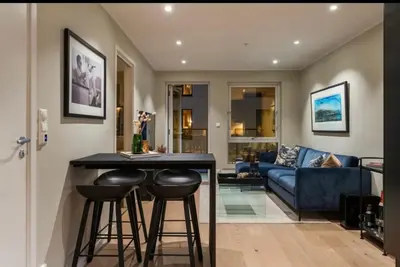 a kitchen and living room with a blue couch at J og F in Bergen