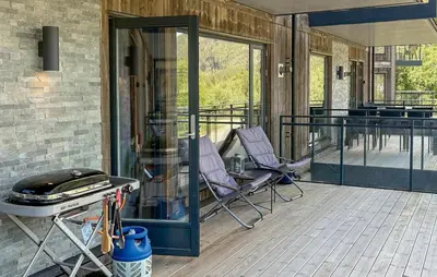 a patio with two chairs and a grill on a deck at 3 Bedroom Awesome Apartment In Hemsedal in Hemsedal