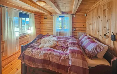 a bedroom with a bed in a wooden cabin at Lovely Home In Røn With House A Mountain View in Ron