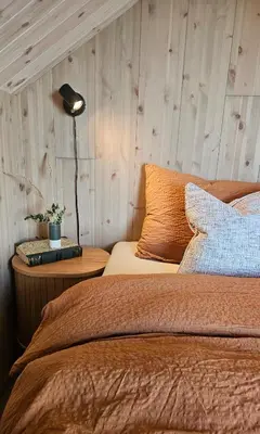 a bedroom with two beds and a lamp on a night stand at Sjåen på Balsnes Gård in Hitra