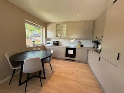 a kitchen with a table and chairs in a room at Moderne 3-roms nær sentrum in Bergen