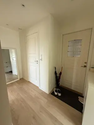 an empty room with two doors and a pair of shoes at Moderne 3-roms nær sentrum in Bergen