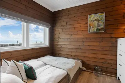 a bedroom with wooden walls and a bed with a window at Fagertoppen 1314B by Vacation Trysil in Trysil