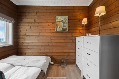 a bedroom with a bed and a wooden wall at Fagertoppen 1314B by Vacation Trysil in Trysil