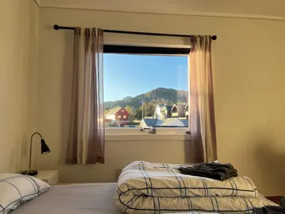 a bedroom with a bed and a window with a view at Fjordside Escape - Spacious apartment with amazing views in Tysnes