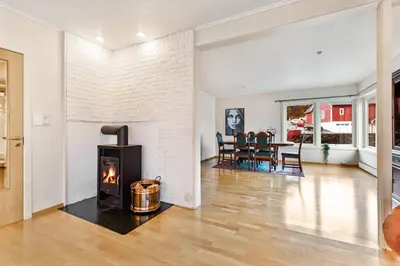 a living room with a fireplace and a table at Fjordside Escape - Spacious apartment with amazing views in Tysnes