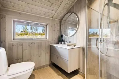 a bathroom with a toilet and a sink and a mirror at Hedda Lenningen - 3 bedroom cabin with view towards Langsua National Park in Etnedal