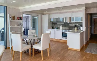 a kitchen and dining room with a table and chairs at Cozy Apartment In Gurskøy With Sauna in Kjellsund