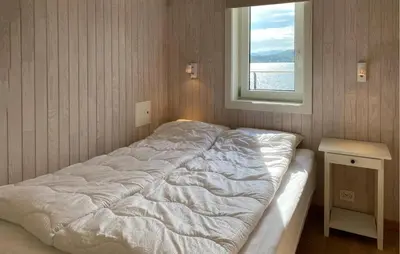 a white bed in a room with a window at Cozy Apartment In Gurskøy With Sauna in Kjellsund