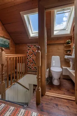 a bathroom with a toilet in a wooden house at Villa Lilleheim in Breim