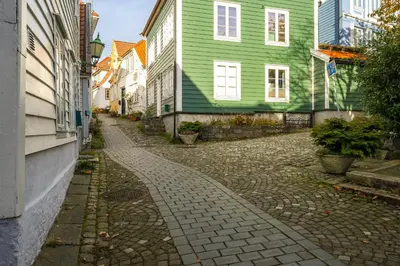 a cobblestone street in a city with green houses at Historisk hus fra 1800-tallet in Bergen
