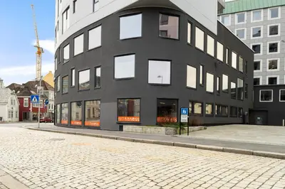 a black building with white windows on a street at Historisk hus fra 1800-tallet in Bergen