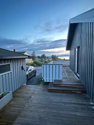 a house with a wooden walkway next to a parking lot at Stort hus i Steinkjer in Steinkjer