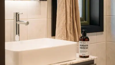 a bottle of alcohol sits next to a bathroom sink at Kvitåvatn Fjellhytter in Gaustablikk