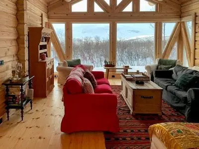 a living room with a red couch in a cabin at Log Cabin With Panoramic Views Of Hallingskarvet in Holo