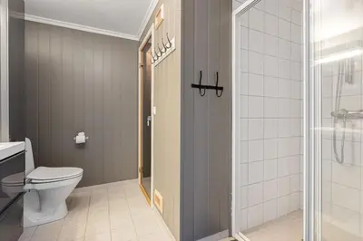 a bathroom with a toilet and a glass shower door at Fagerasen 790D by Vacation Trysil in Trysil
