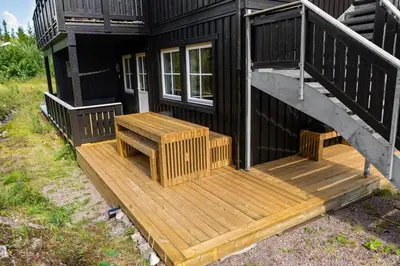 a wooden deck with a bench on a house at Fagerasen 790D by Vacation Trysil in Trysil