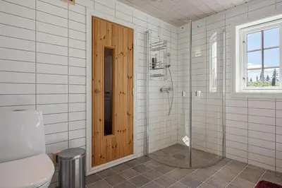 a bathroom with a toilet and a wooden door at Solsiden 16B by Vacation Trysil in Trysil