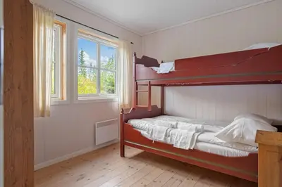 a bedroom with a red bunk bed with a window at Fagerasen 760B by Vacation Trysil in Trysil