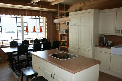a kitchen with a sink and a table with chairs at Gemütliche Ferienwohnung am Fjord